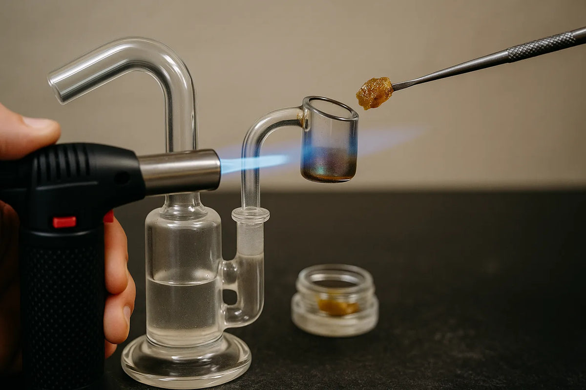 Egy ember dab rig-et használ, hogy cannabis koncentrátumot inhaláljon, közelről nézve egy nyugodt otthoni környezetben.
